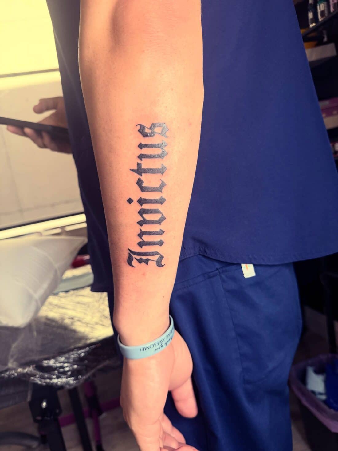 Tattoo by Apollonia Ink in Barrie, Invictus in blackletter lettering down a forearm