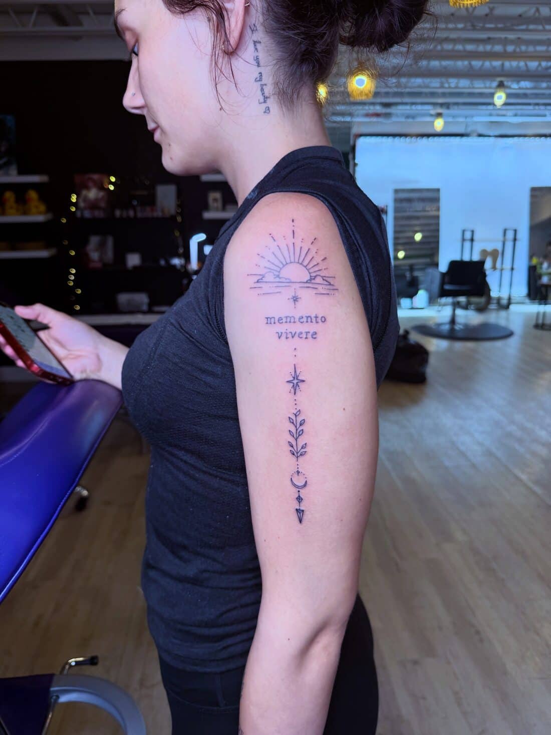 Tattoo by Apollonia Ink in Barrie, fine line botanical with a sunrise and script on an upper arm