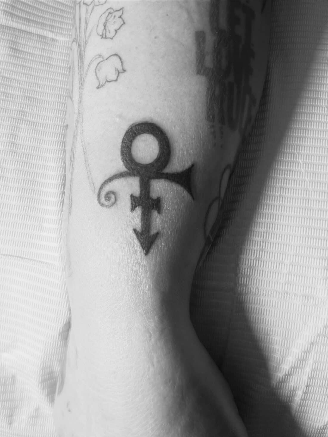 Tattoo by Apollonia Ink in Barrie, Prince love symbol in black and grey on a forearm