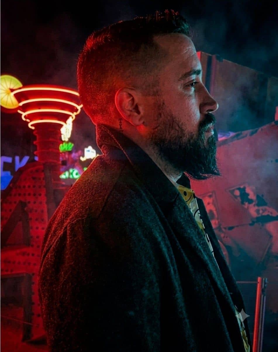 Jake Brewer in profile under neon signs at night